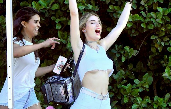 Candids of Bella Thorne enjoying herself at Magic Mountain in a tiny crop t...