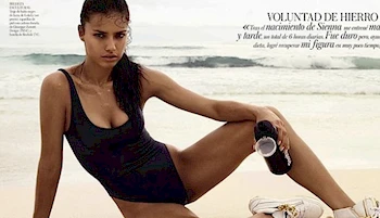 Adriana Lima on her side in a swimsuit at the beach