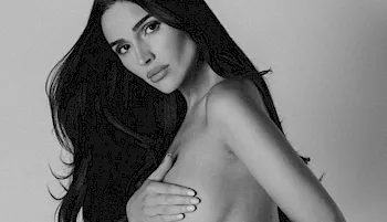 Black and white photo of pretty brunette holding her boob