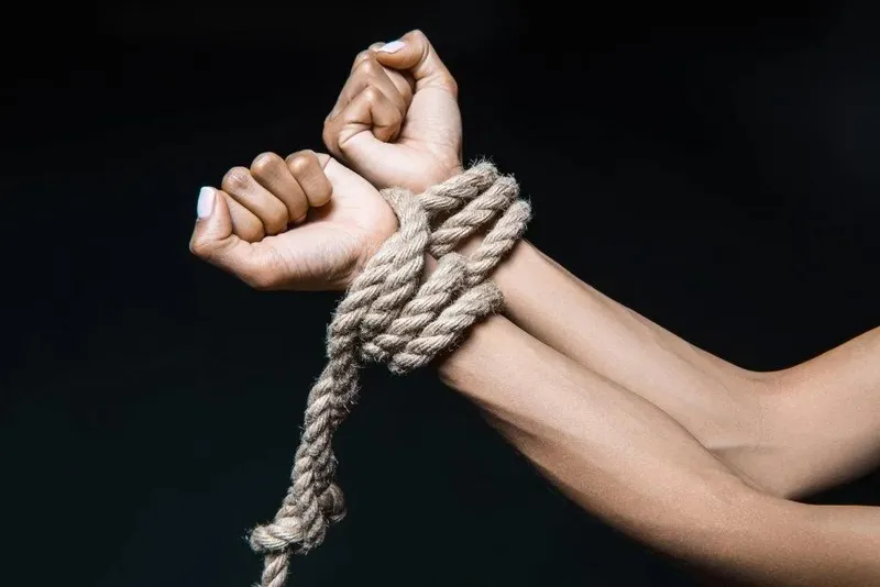 A pair of hands tied up with rope
