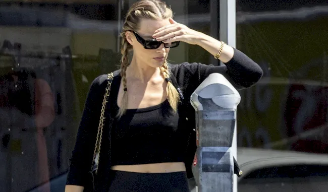 Pretty blonde trying to figure out a parking meter