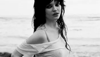 Black and white photo of pretty girl in a wet dress at the beach