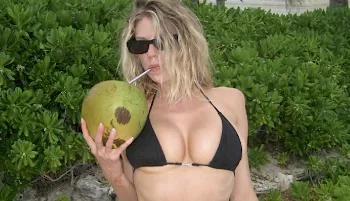 Bikini babe enjoying a coconut drink at the beach