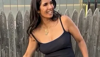 Indian woman smiling while braless in a black dress