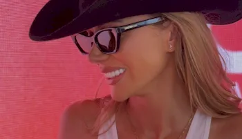 Close up of sexy blonde cow girl wearing a hat and sun glasses