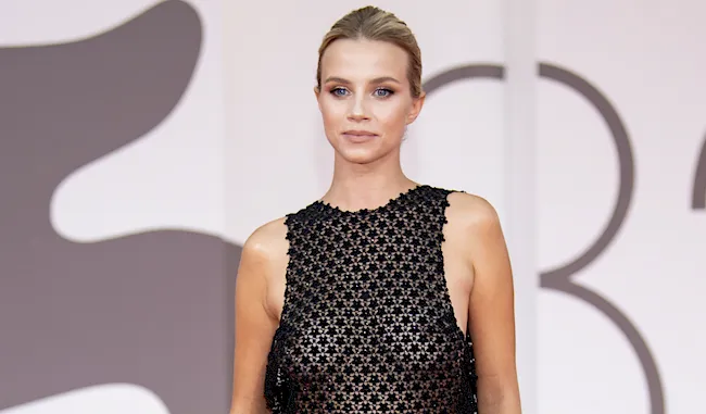 Sexy blonde woman braless in a sheer top on the red carpet