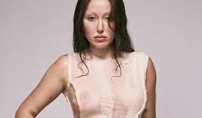 Noah Cyrus posing in a see through white dress