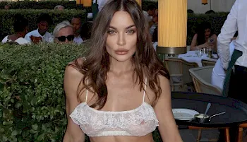 Fashion model wearing a tiny sheer top at a patio in Paris