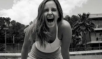 Emma Watson lean forward with a big laugh on her face