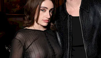 Rachel Sennott posing at a party in a see through top