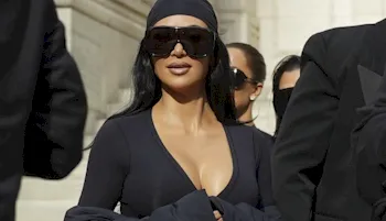 Kim Kardashian in a tight top and wearing a bandana and sunglasses