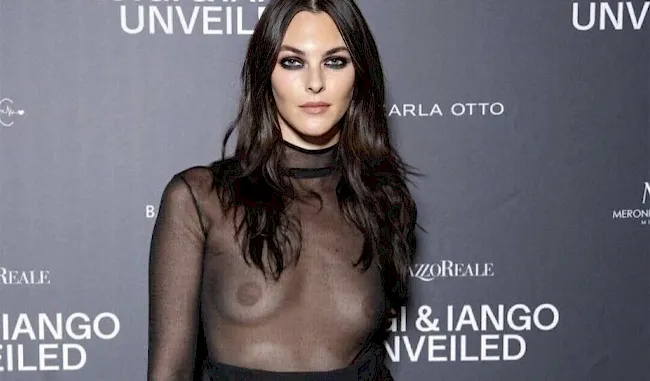 Pretty Italian fashion model posing braless in a sheer top on the red carpet