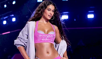 Sexy model strike a pose on the runway wearing a tiny pink top