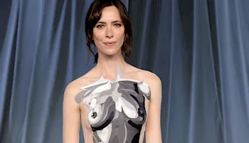 Woman posing in a black and white top with artistic breasts painted on it