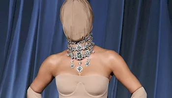 Woman with her face completely covered posing with hands on hips on the red carpet