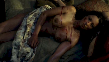 Topless woman laying down covered in dirt and scratches