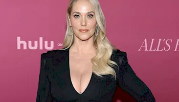 Cropped photo of blonde woman showing big breast cleavage on the red carpet