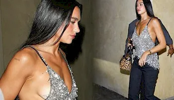 Dua Lipa wearing a silver top and black pants