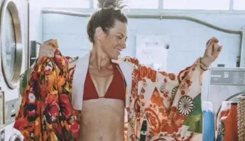 Evangeline Lily wearing a red bra and robe inside a laundromat