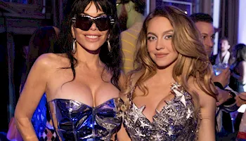 Sydney Sweeney in a shiny silver dress at a party with a woman wearing a similar dress