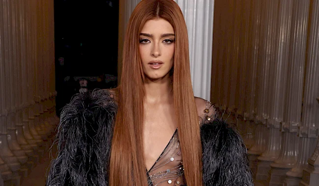 Close up a woman looking into the camera wearing a see through dress