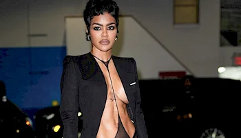 Cropped from waist up view of git black woman walking by in a revealing outfit