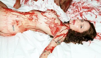 Halsey nude and on her back in bed while covered in blood