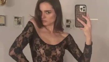 Blurry quality of a woman taking a braless selfie in a lace dress
