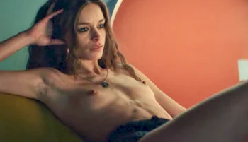 Topless Italian actress Francesca Colucci leaning back on a sofa