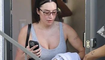 Close up of a woman leaving a building wearing a gym top