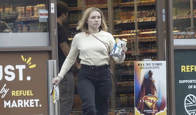 Frontal of woman leaving a gas station with small chip bags in her hands