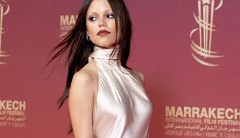 Close up of Jenna Ortega walking down the red carpet with her head turned