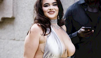 Close up side view of a Latina woman in a silver dress walking by