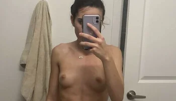 Close up of topless girl taking a selfie with phone covering her face
