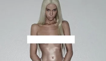 Cropped frontal of woman looking like a plastic doll nude and with a white bar across her breasts