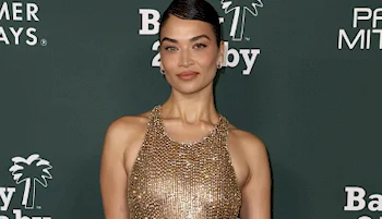 Close up of female model with a slight smile posing on a red carpet