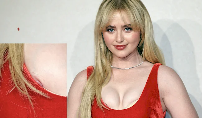 Blonde woman in red dress posing confidently on the red carpet