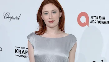 Redhead woman wearing shiny silver dress at event