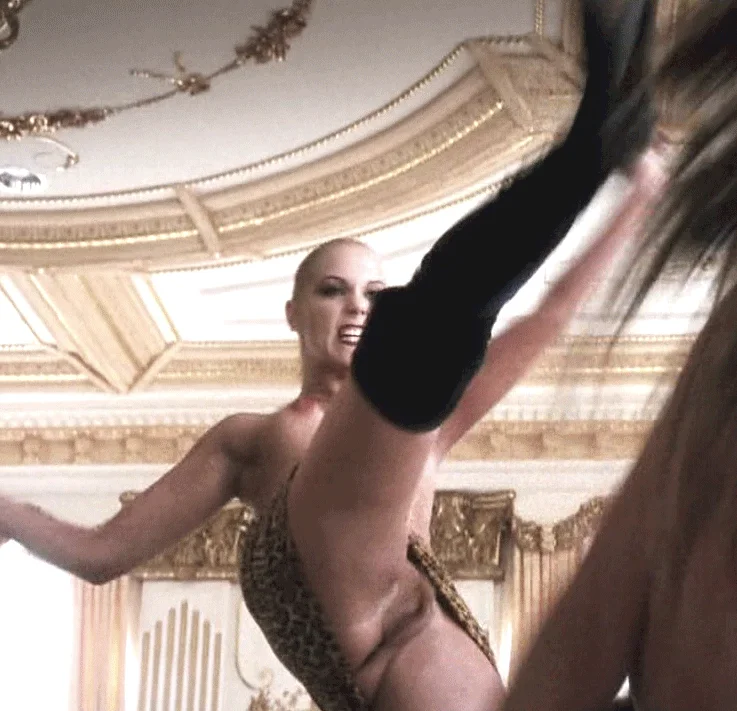 Elizabeth Berkely topless and making a fierce face while kicking another person. Her vagina is on full display.