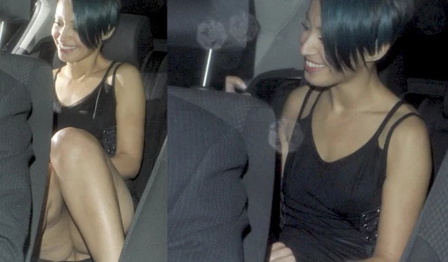 A girl caught without panties while sitting in the back of a car. She is smiling