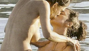 Two naked women kissing while in ocean water