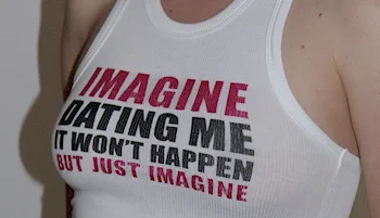 Close up of a woman wearing a tank top with the words IMAGINE DATING ME - IT WON'T HAPPEN - JUST IMAGINE