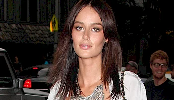 Close up of a woman with long brown standing outside at night.