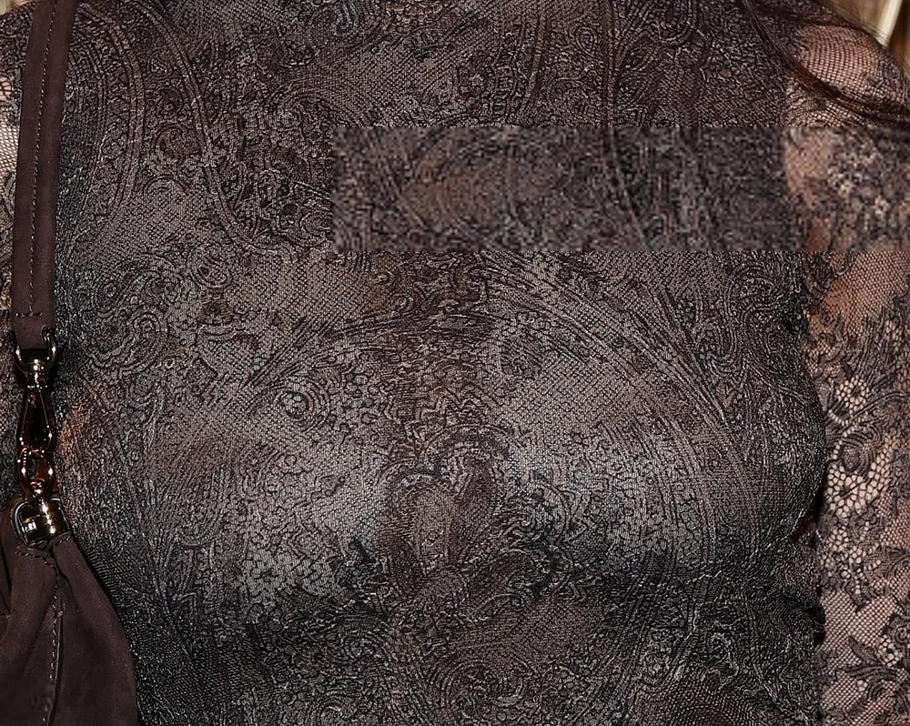 CayleeCowanSeeThroughEtroFSPic2 Close-up of a woman wearing a dark, sheer lace top with an intricate paisley pattern.