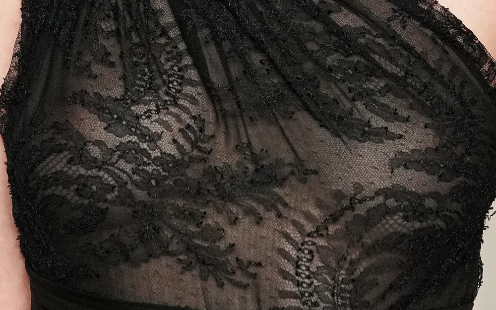 Close-up of a black lace garment with a detailed floral pattern.