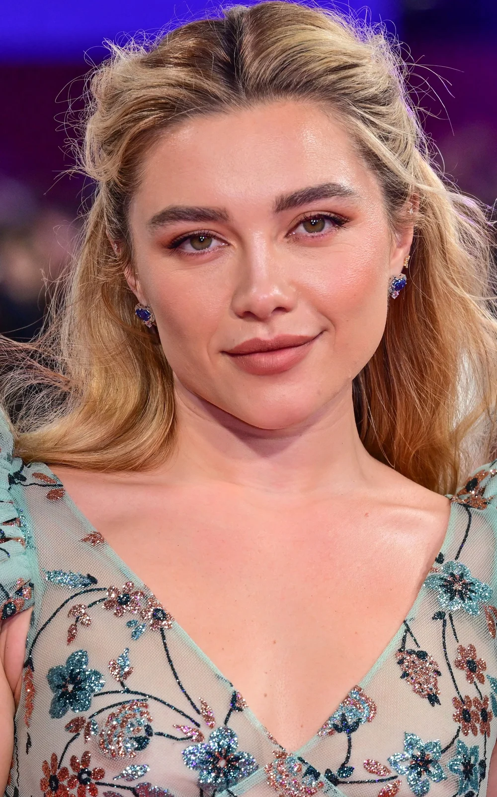 FlorencePughSeeThroughKlaraAndTheSunBFILFFPic1 Florence Pugh wearing blue floral-patterned dress and blue-and-gold stud earrings.