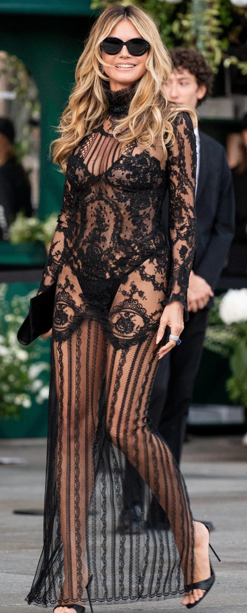 HeidiKlumLace2026VogueWorldPic1 Heidi Klum wearing a long-sleeved, sheer black lace gown and sunglasses.