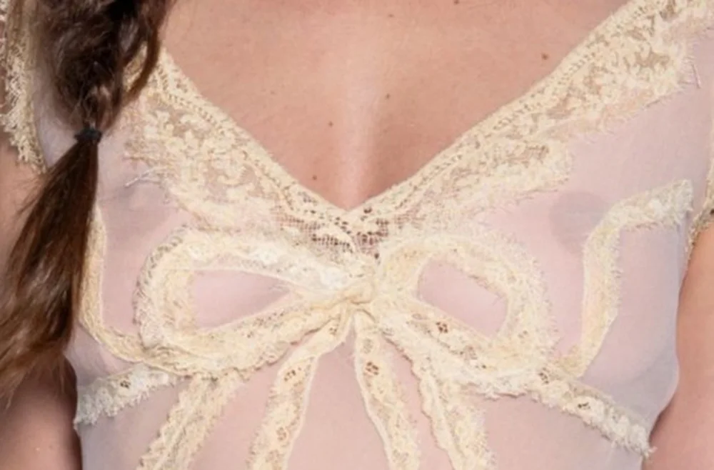 ScoutWillisSeeThrough26ErmannoScervinoMilanPic2 Sheer, pale beige top with a lace-trimmed V-neckline and large lace bow detail on the chest.