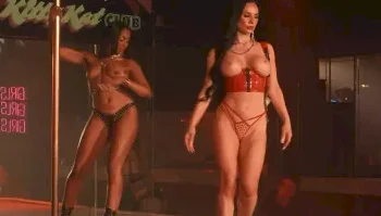 Two topless dancers perform on a stage in a club with a neon Kit Kat Club sign in the background.