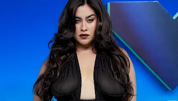 Lauren Jauregui posing against a blue backdrop.